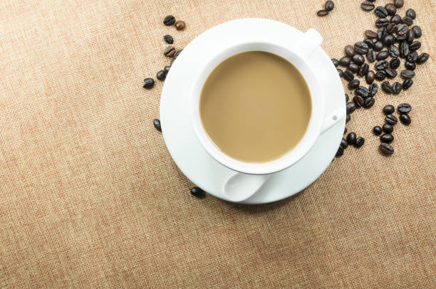 istock Cup of coffee with coffee beans on burlap warm cup on brown background 905275244