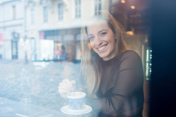 istock Woman drinking coffee in a cafe and looking at camera 905280014