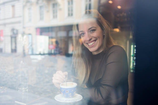 istock Woman drinking coffee in a cafe and looking at camera 905280068