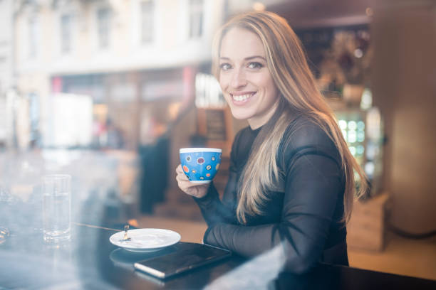 istock Woman drinking coffee in a cafe 905289552