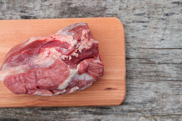 istock Raw pork meat on cutting board on a table. Top view 905292994