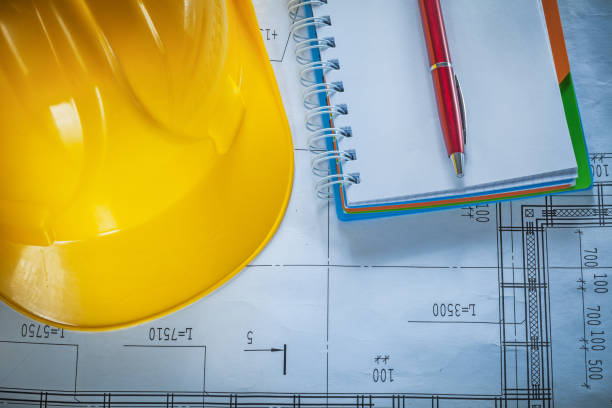 istock Safety building helmet notepad pen on blueprint 905300818