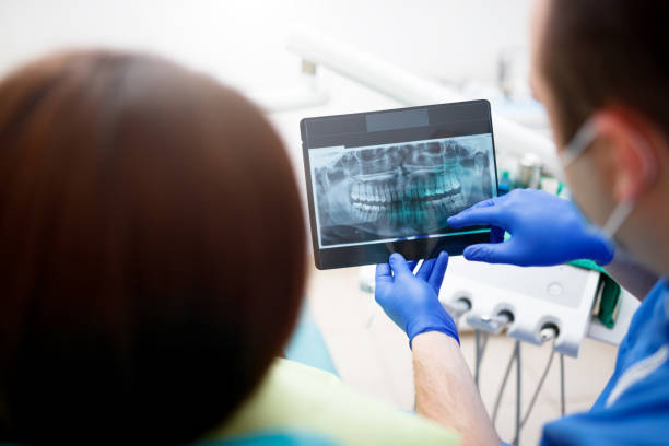 istock Dentist showing a patient her x-ray 905301324