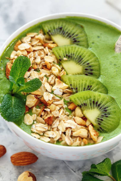 istock Smoothie bowl with spinach, granola,kiwi and nuts. 905303540