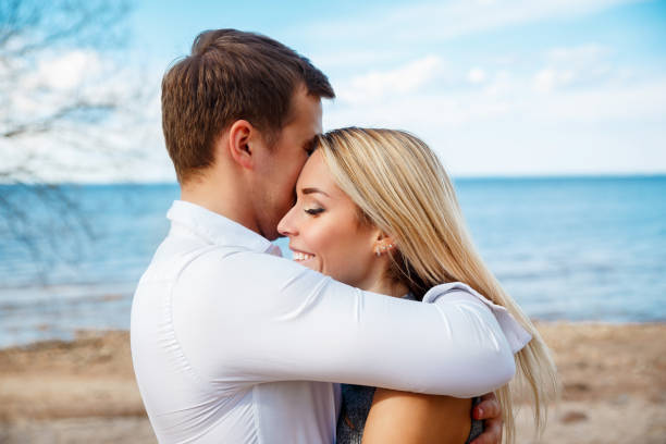 istock Romantic young couple standing head to head at beach 905304572