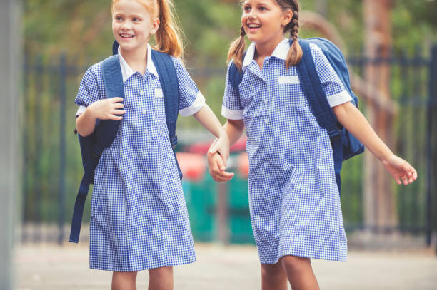 istock Schoolgirls in uniform with back pack. 905304732