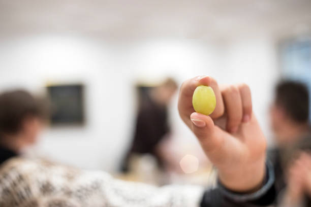 istock Young Boy Holding Green Grape Berry in Hand 905309040