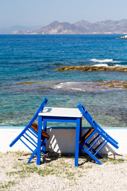istock Painted chairs and table by the sea 905315460
