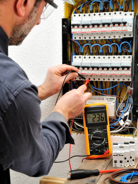 istock Electrician technician at work with protective helmet on a residential electric panel 905322340