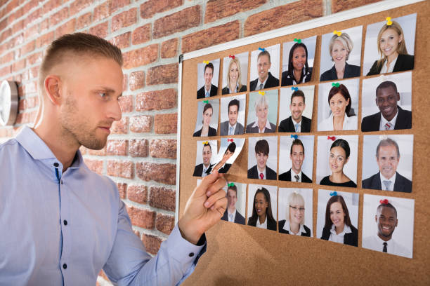 istock Businessman Selecting Candidates Photo On Corkboard 905323436