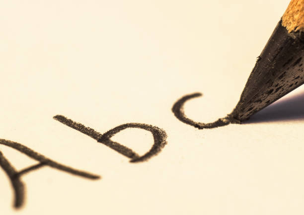 hand writing the word yes!  on paper with pencil