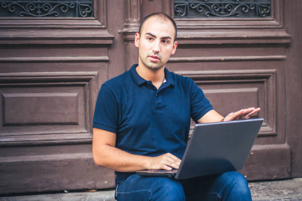istock Young man with laptop outdoor. 905328728
