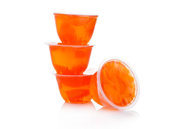 Single cups with mandarins in fruit jelly on white background