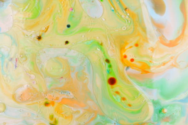 istock Multicolored oil drops on a liquid, abstract colored background, pop art texture, yellow circles with bright drops of paint, minimalism, pastel pattern, art 905332424