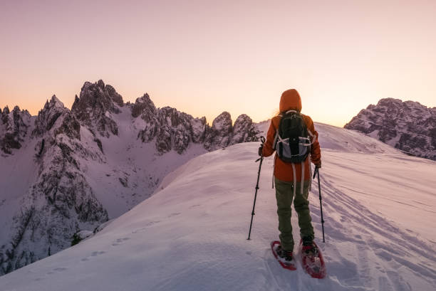 junge frau explorer in ätherisch landschaft am oberen rand der verschneiten berge wandern - cortina dampezzo stock-fotos und bilder