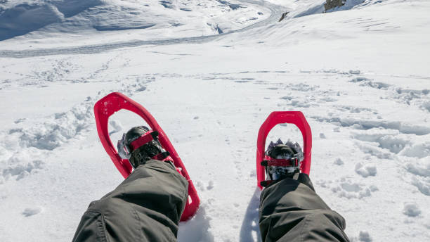 Point of view image of man in snowshoes preparing to explore the mountains Point of view image of man in snowshoes preparing to explore the mountains snowshoeing snow shoe red stock pictures, royalty-free photos & images