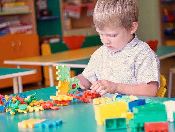 istock Little boy in the children's room plays in the constructor on the table. 905348430