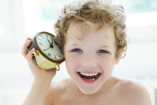 laughing little boy listen an antique clock. - clock clock hand antique clock face imagens e fotografias de stock