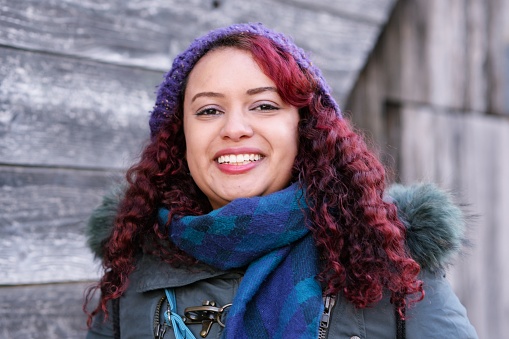 Portrait of a mid adult black woman in warm clothes.