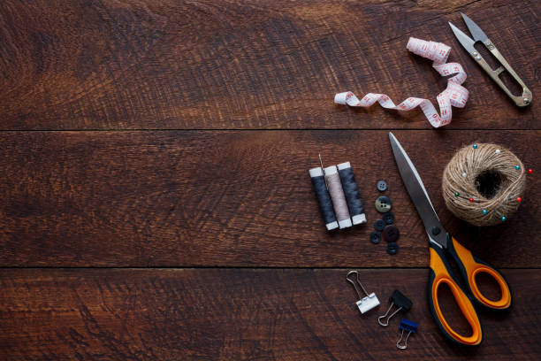 istock Top view aerial image fashion designer background concept.Flat lay sewing accessory or tailor tool work shop on modern rustic brown wooden at home office desk studio.Space for creative design mock up. 905357342