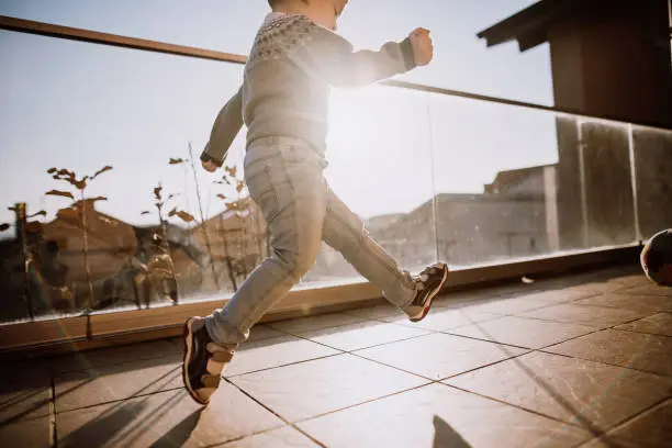 Photo of Boy playing with ball on balcony