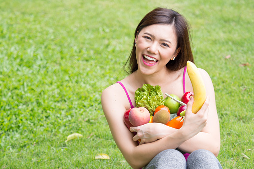 Young beautiful asian woman holding fresh clean food with vegetables and fruits for good healthy over green background, healthy food woman for diet
