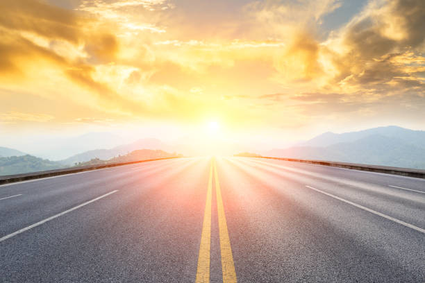 asphalt road and mountains with foggy landscape at sunset asphalt road and mountains with foggy nature landscape at sunset horizon over land stock pictures, royalty-free photos & images