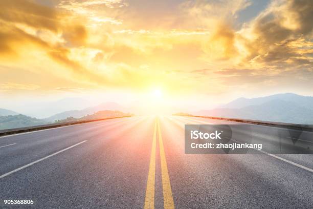 Asphalt Road And Mountains With Foggy Landscape At Sunset Stock Photo - Download Image Now