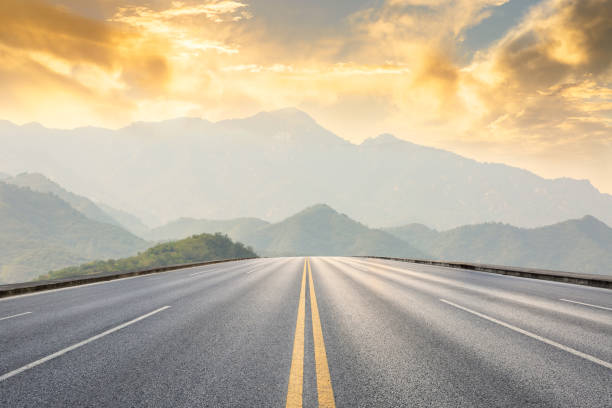 asphalt road and mountains with foggy landscape at sunset asphalt road and mountains with foggy nature landscape at sunset road stock pictures, royalty-free photos & images