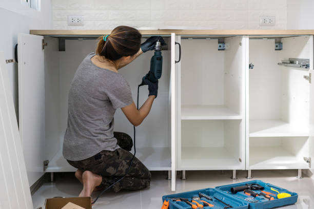 Young woman using electric screwdriver to installation