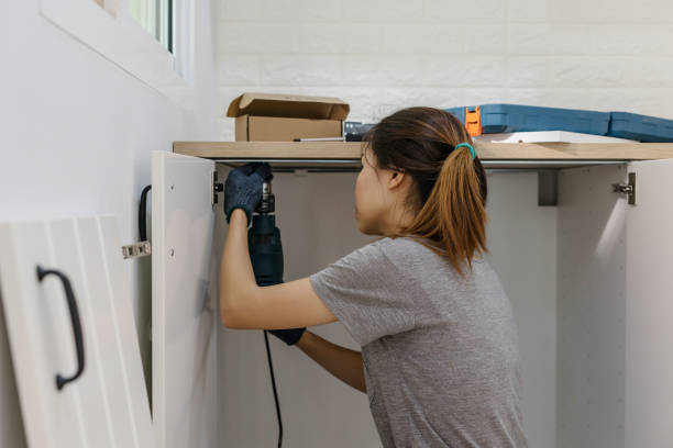 istock Young woman using electric screwdriver to installation 905374938
