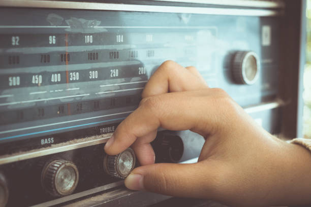 Listening radio Retro lifestyle - Woman hand adjusting the button vintage radio receiver for listen music or news - vintage color tone effect. stereo photos stock pictures, royalty-free photos & images