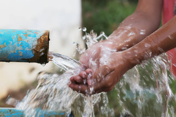istock close up children hand and water drop splash in pipe 905382416