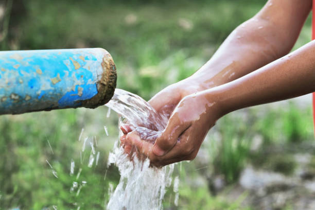 istock close up children hand and water drop splash in pipe 905382622