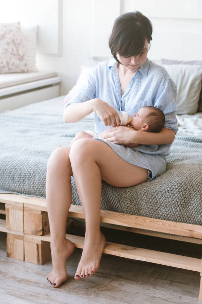 istock feeding the newborn with a mixture in a bottle 905382826