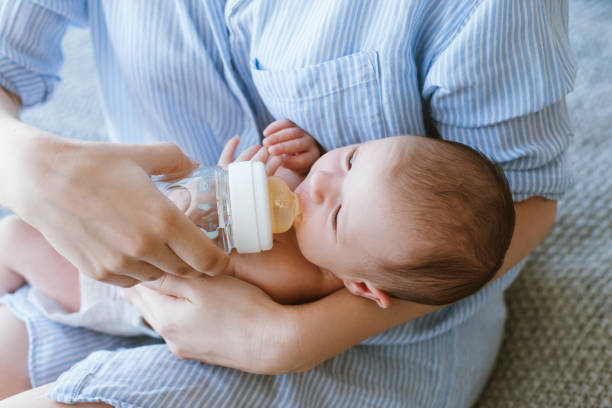 istock feeding the newborn with a mixture in a bottle 905382886