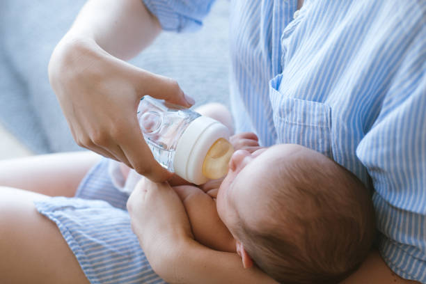 istock feeding the newborn with a mixture in a bottle 905382900