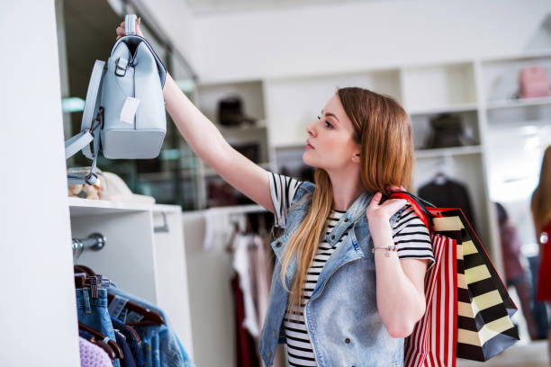 ショッピング バッグ ハンドバッグ彼女のカジュアルなスタイルに一致するを選択すると若い女性の買い物客 - club wear ストックフォトと画像