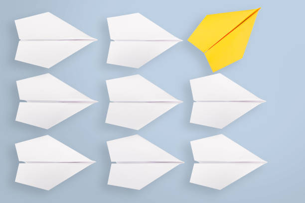 istock Change concepts with yellow paper airplane leading among white 905392958