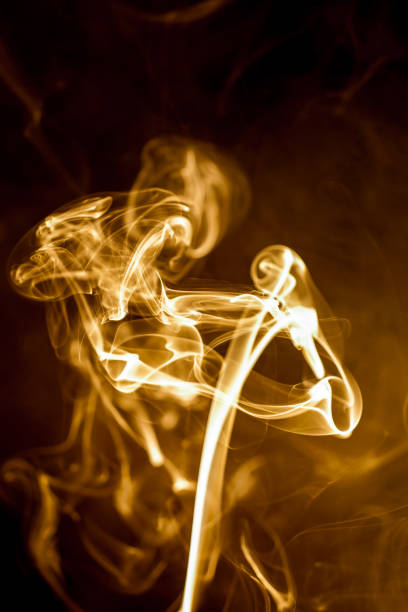istock Yellow smoke on black background. 905395696