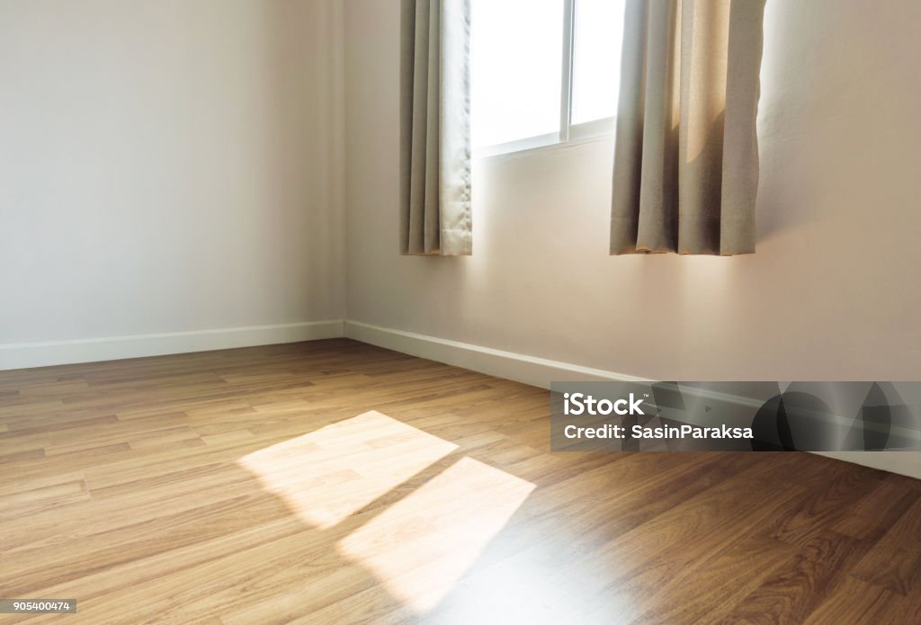 Interior space, empty room, laminate wooden floor with opened window receiving sunlight in the morning Corner Stock Photo