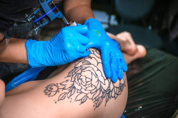 istock Professional tattooer working on professional tattoo machine gun in tattoo studio 905400682