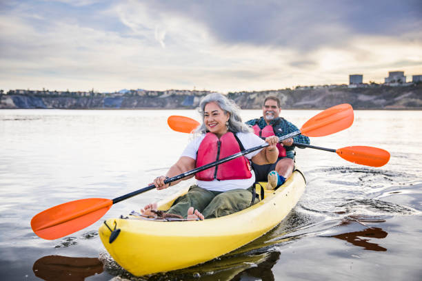 Senior Mexican Couple Kayaking A beautiful senior Mexican couple kayaking kayaking stock pictures, royalty-free photos & images