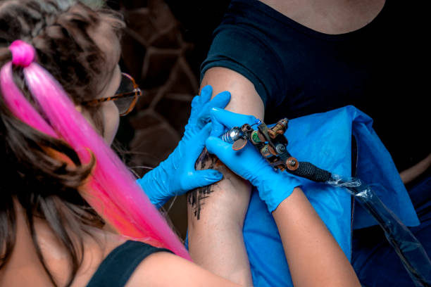 istock Professional tattoo artist making tattoo in salon a workshop studio 905401270