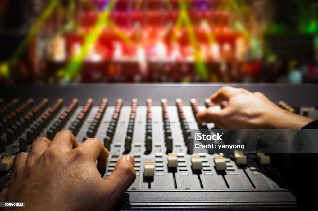 sound engineer hands working on sound mixer, background of concert stage Technician Stock Photo