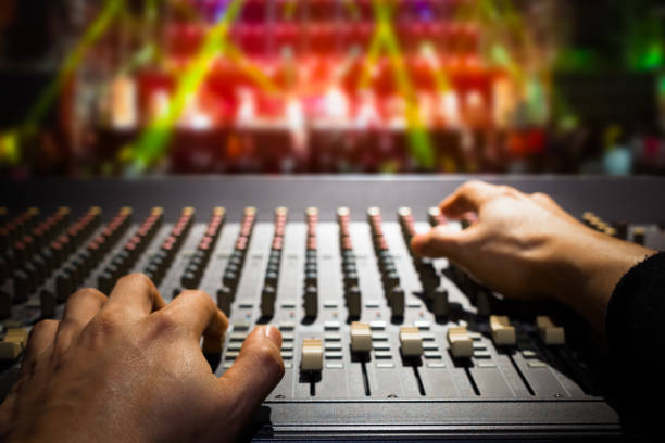 sound engineer hands working on sound mixer, background of concert stage stock photo