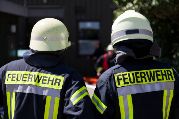 alemán bomberos (feuerwehr) está parado cerca de un accidente - action fire department car men fotografías e imágenes de stock