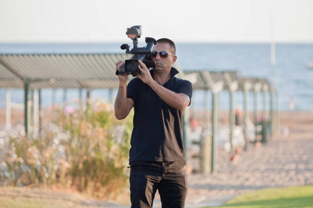 istock Young man and his video camera 905405956