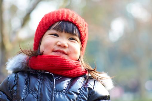 portrait of lovely little asian girl outdoor in the autumn park