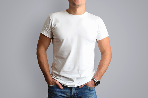 Mockup  white T-shirt on a young mildew in blue jeans. Isolated on a gray background.